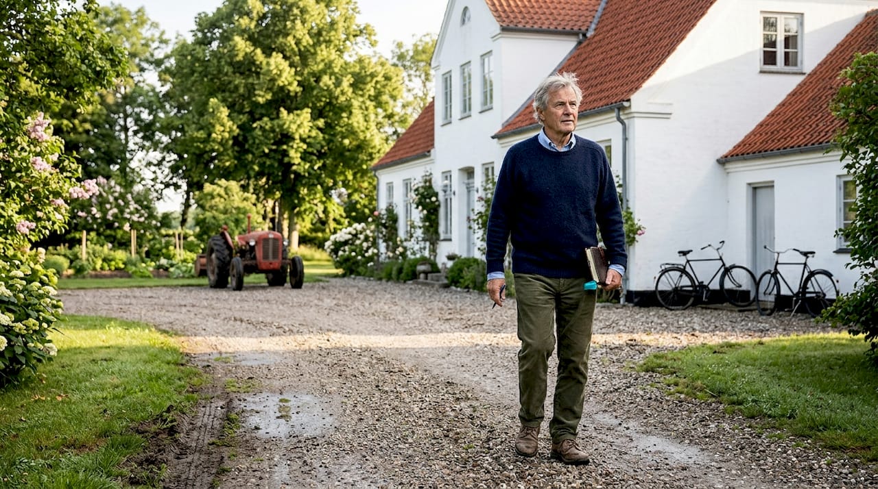 En mand spadserer foran en dansk herregård