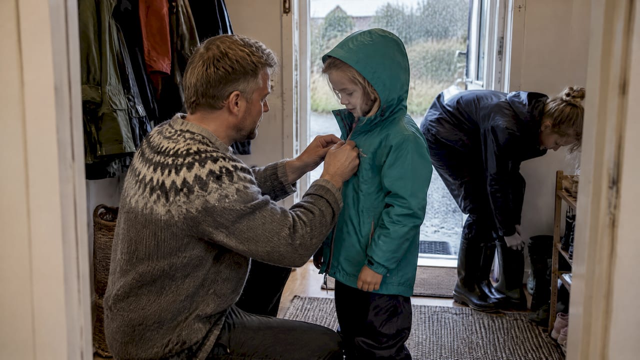 Familien tager regntøj på i sommerhuset